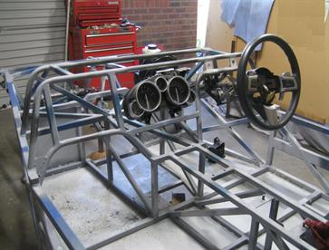 The scuttle and dash mounting frame was welded in place to improve torsional rigidity of my longer than normal cabin area of the chassis.  The MX5 instrument cluster was originally in the centre of the dash but after registration it was moved to behind the steering wheel.